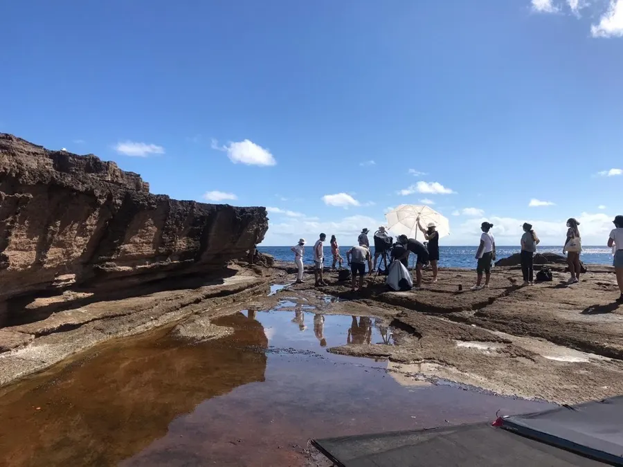 The crew reflected in a rock pool on location