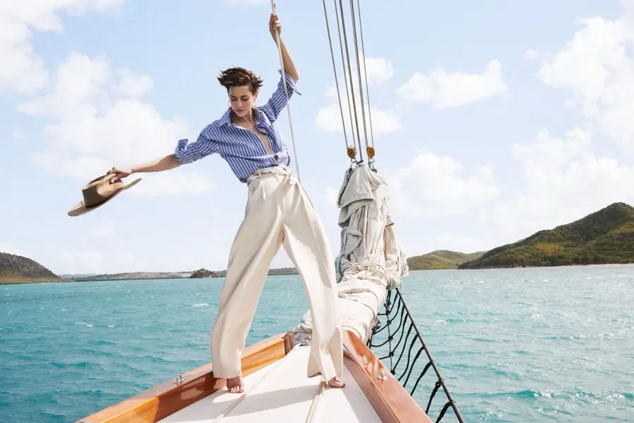 Model throwing a hat from the bow of a schooner
