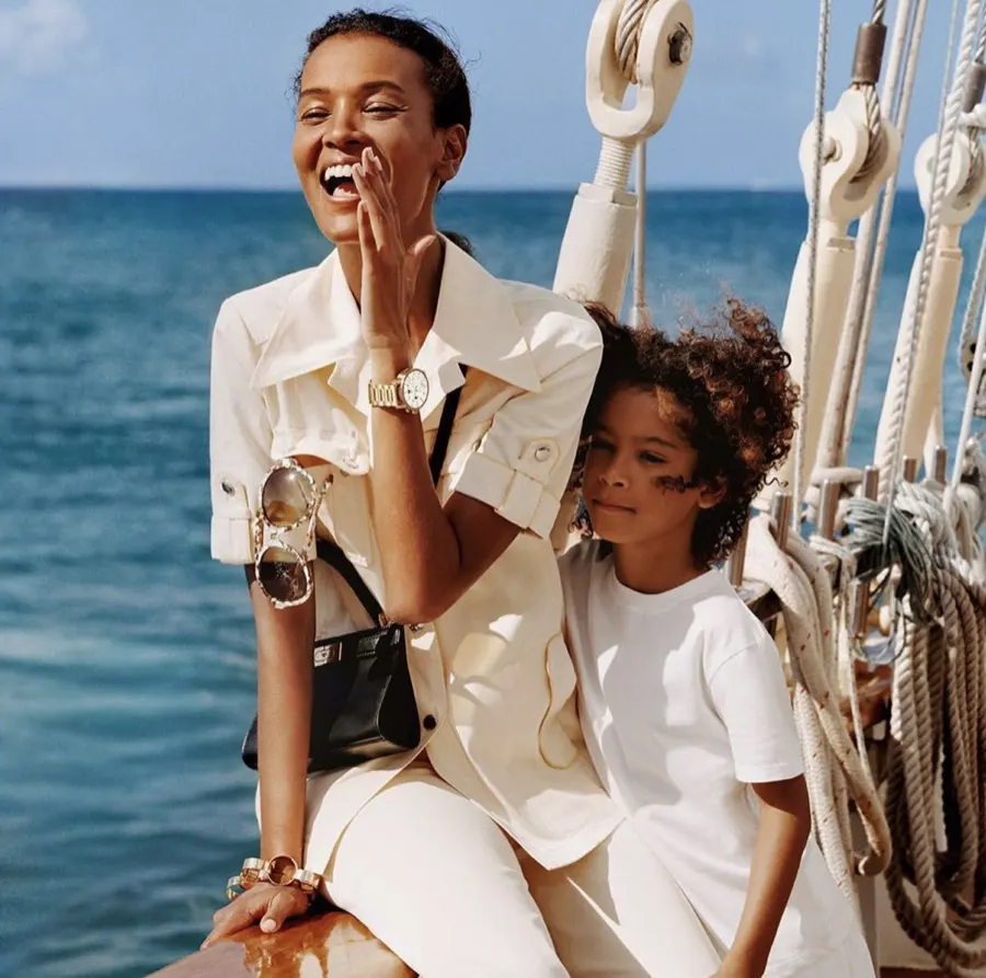 Model laughing with a child on deck