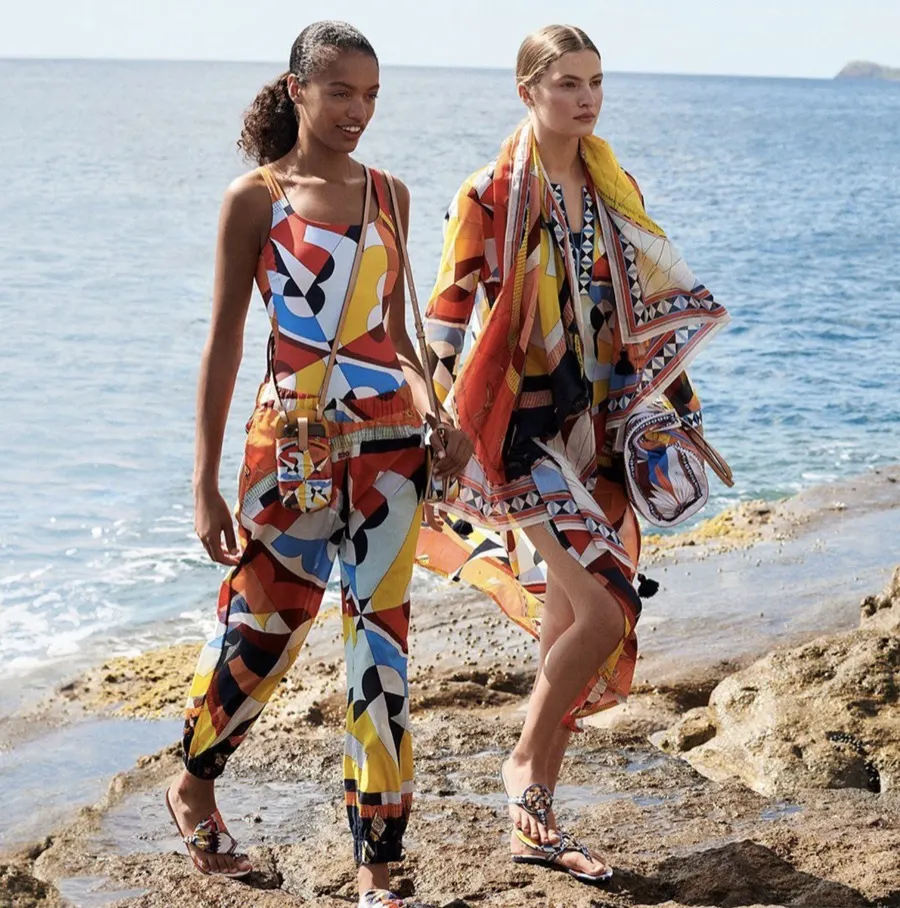 Two models in bold prints on a rocky shore